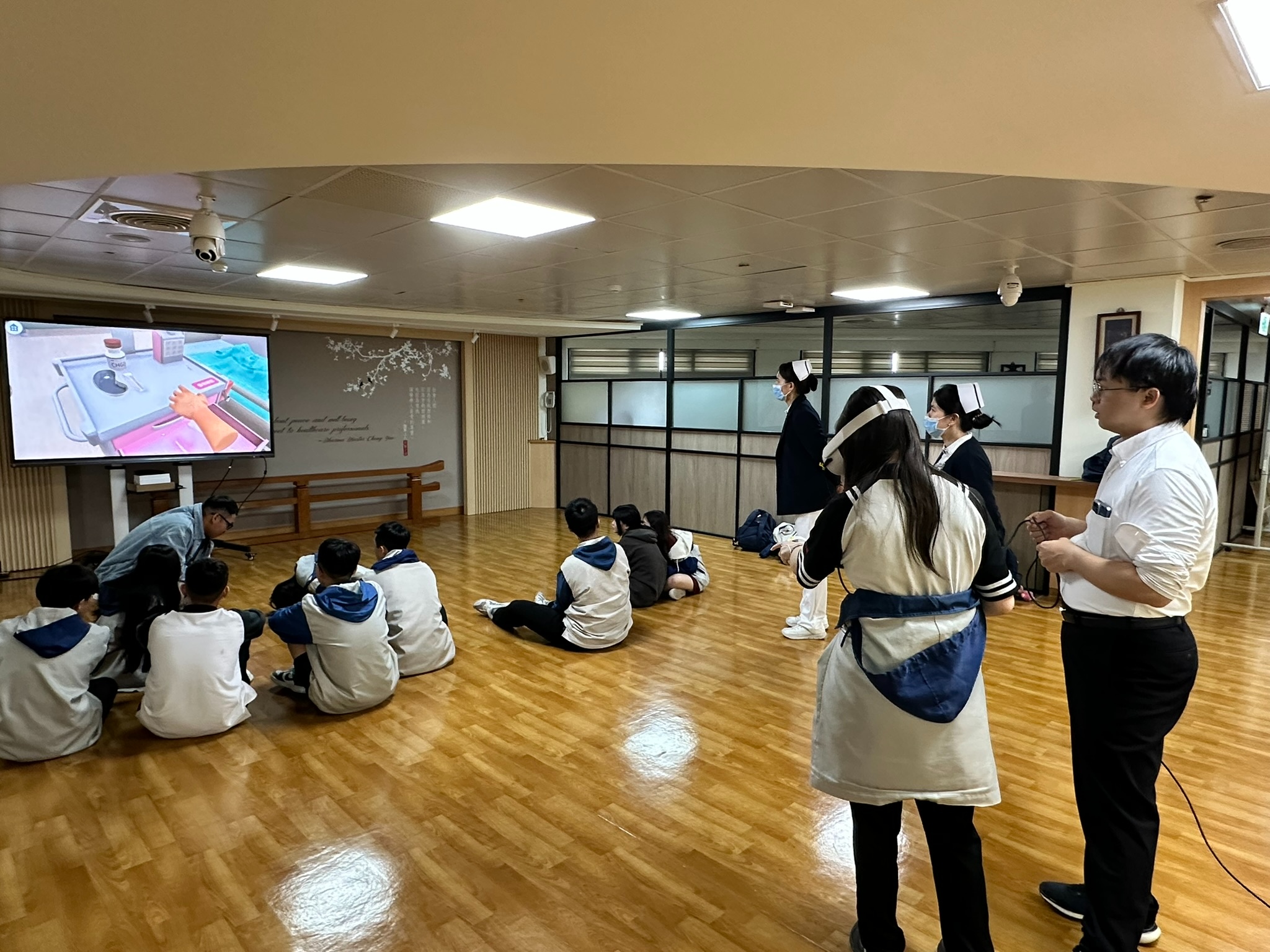 同學們一起觀看同學操作VR靜脈注射的影像,大家聚精會神覺得有趣。