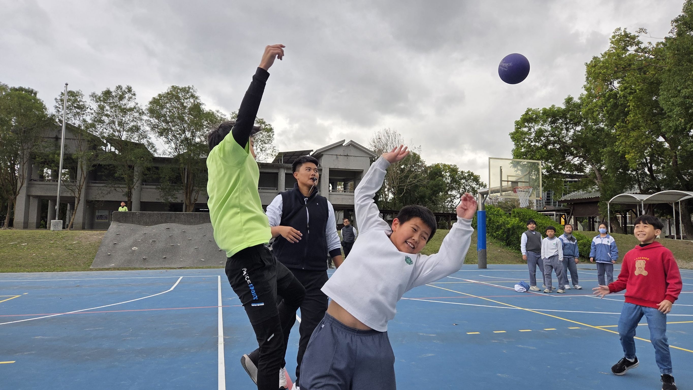 兩校學生在躲避球友誼賽中交流,笑聲充滿球場。