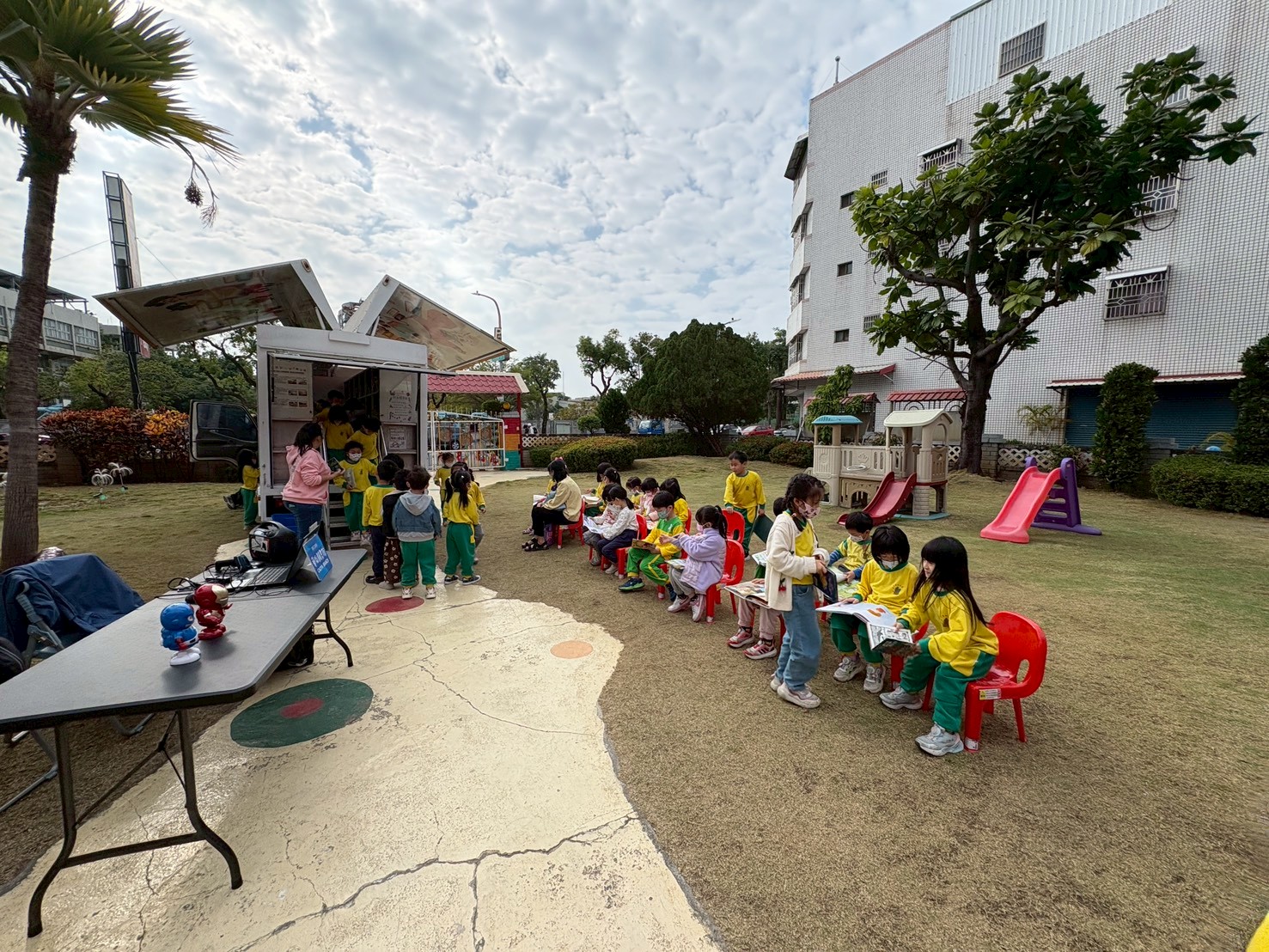 孩子們圍坐在行動圖書車旁翻書閱讀，在故事與書香中度過美好的學習時刻。