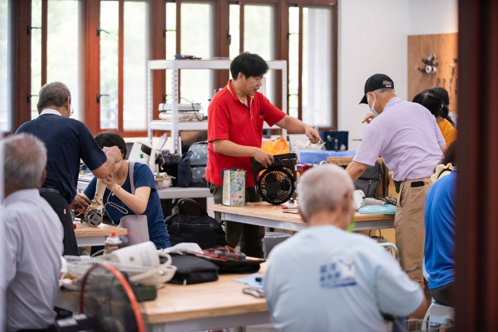 鳳山靜思堂西102生生家電室熱鬧滾滾。桌面上擺放著待修的電風扇、小家電與各式工具設備,志工專注拆解、檢測、清潔與組裝,工具聲與笑聲交織,現場充滿學習與陪伴的溫暖場域。