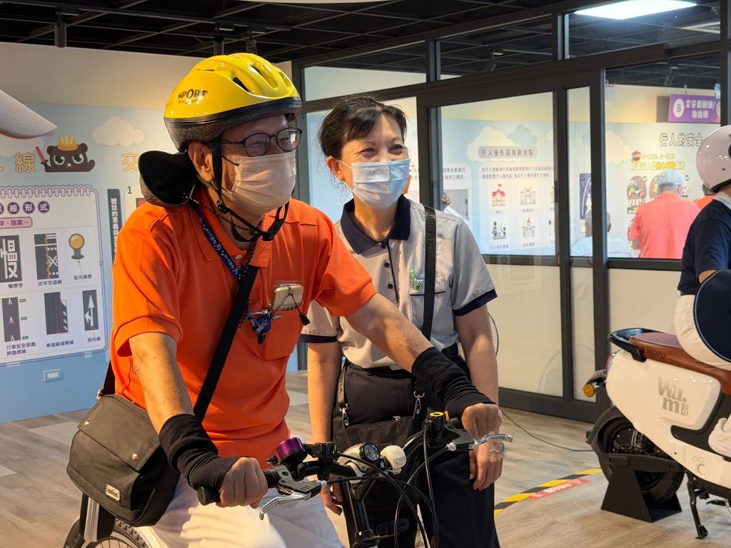 在AR模擬腳踏車上努力很久的陳國珍（前），笑著說：「多練習幾次就可以掌握它的節奏」。