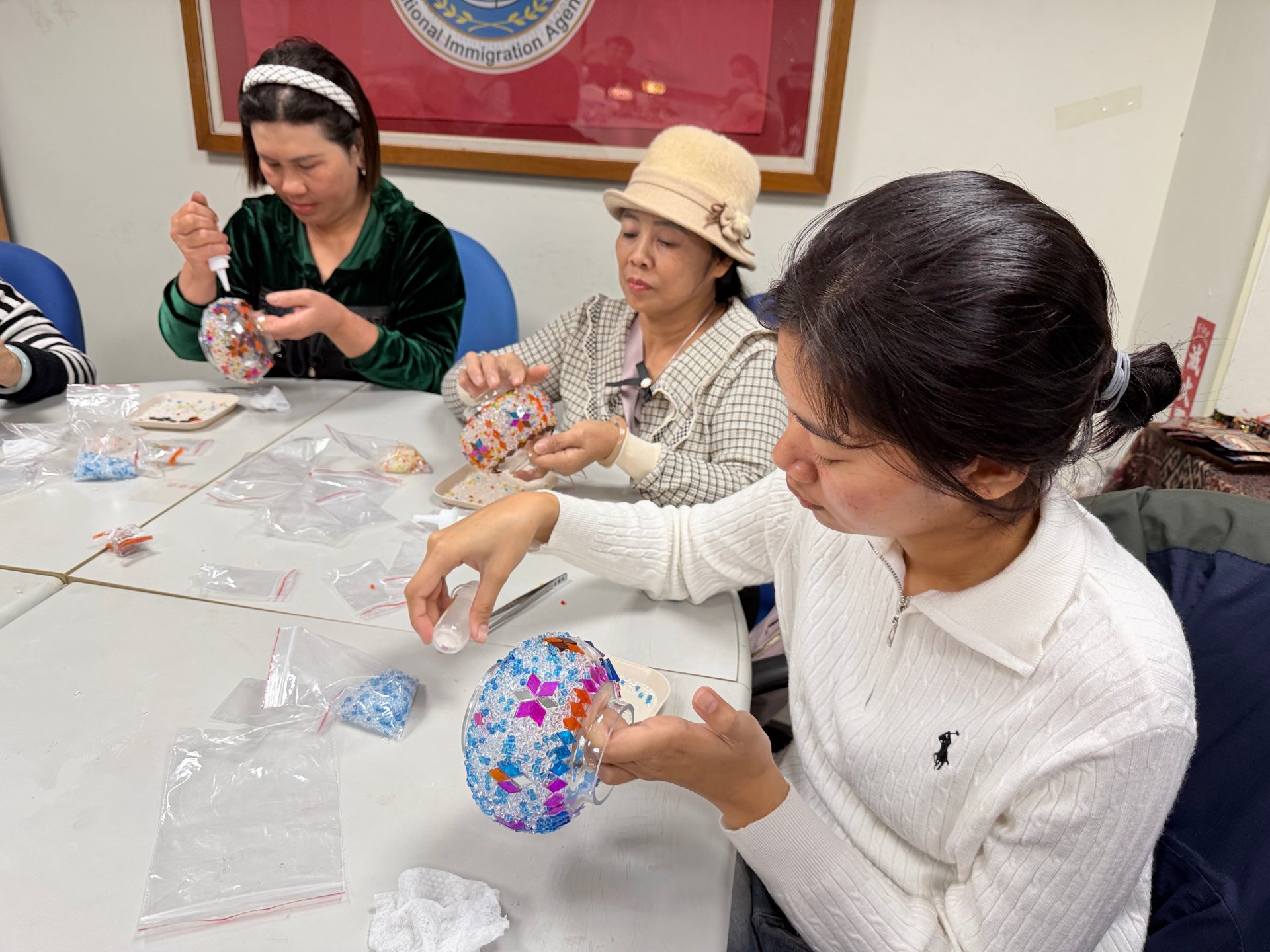 新住民姊妹專注投入土耳其玻璃燈手作課程，在講師指導下細心拼貼彩色玻璃片，發揮巧思創作專屬燈飾。