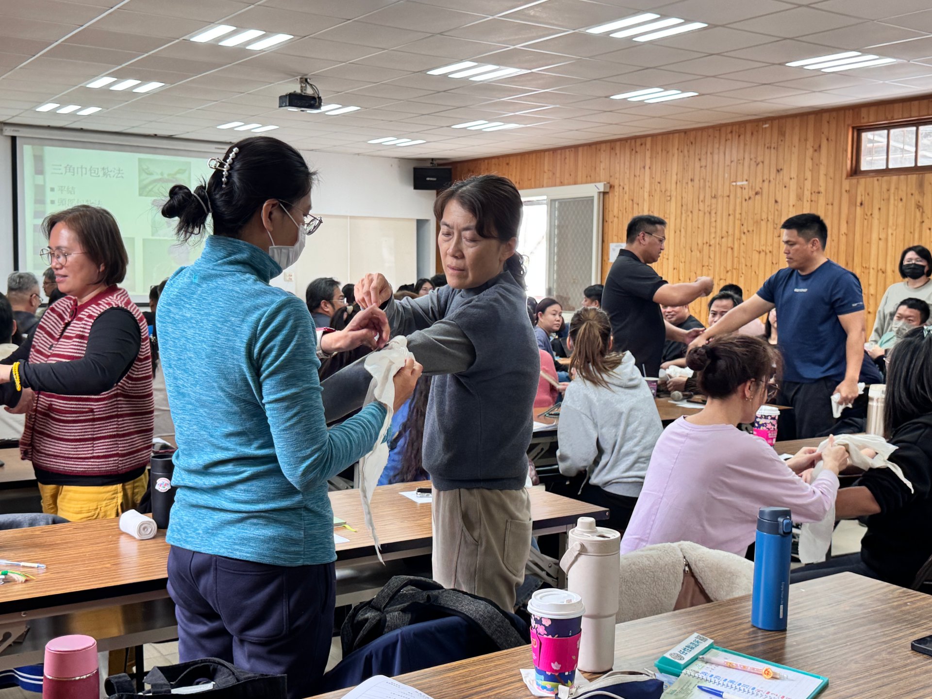 光復鄉防災士培訓課程，在教官說明下學員互相練習包紮。