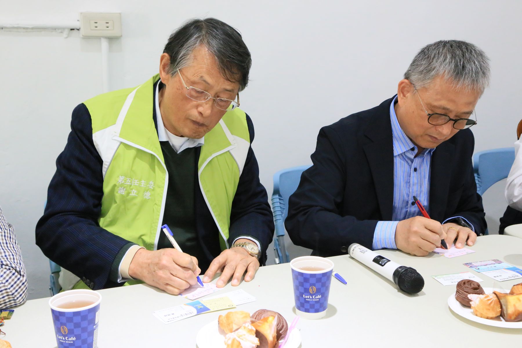 家扶主委謝立德（左）與光電發電系統同業公會理事長林新寶（右）一同寫下祝福卡片