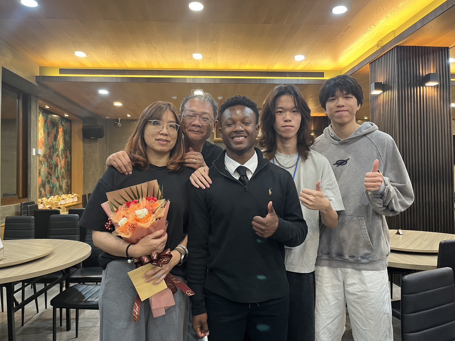 美國學生獻上感謝款待的花束並與寄宿家庭合影。