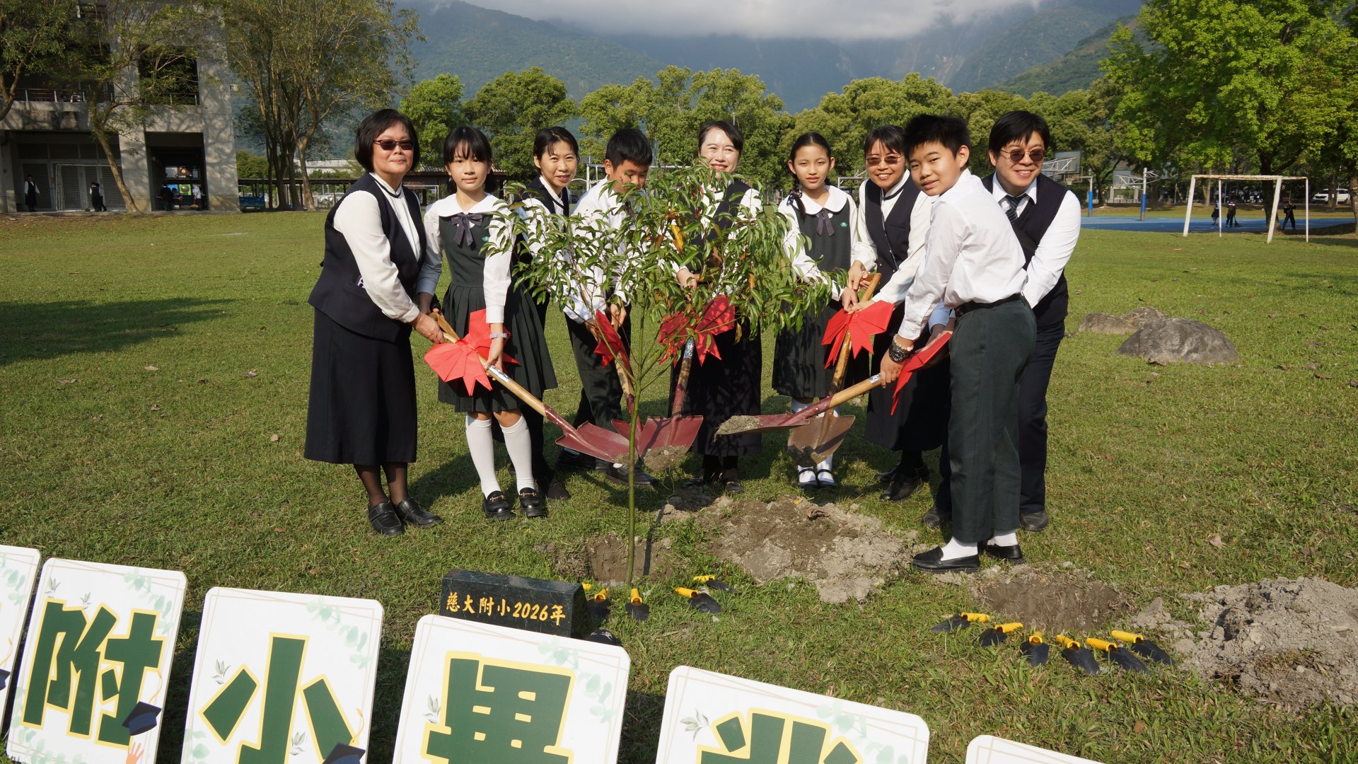 各班代表與校長合力將畢業樹植入樹穴。