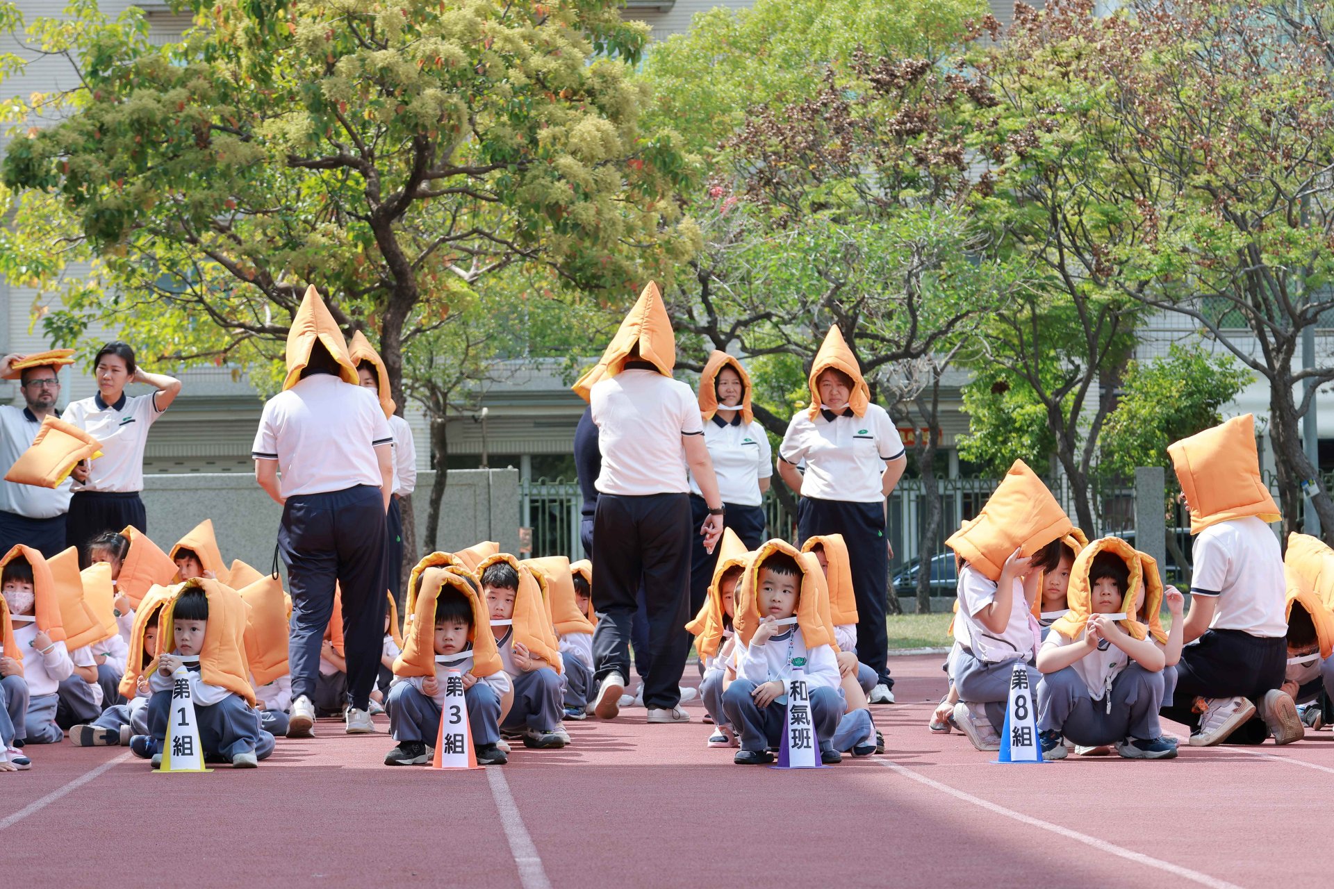 孩子迅速就地掩護以防災帽保護頭部降低傷害。