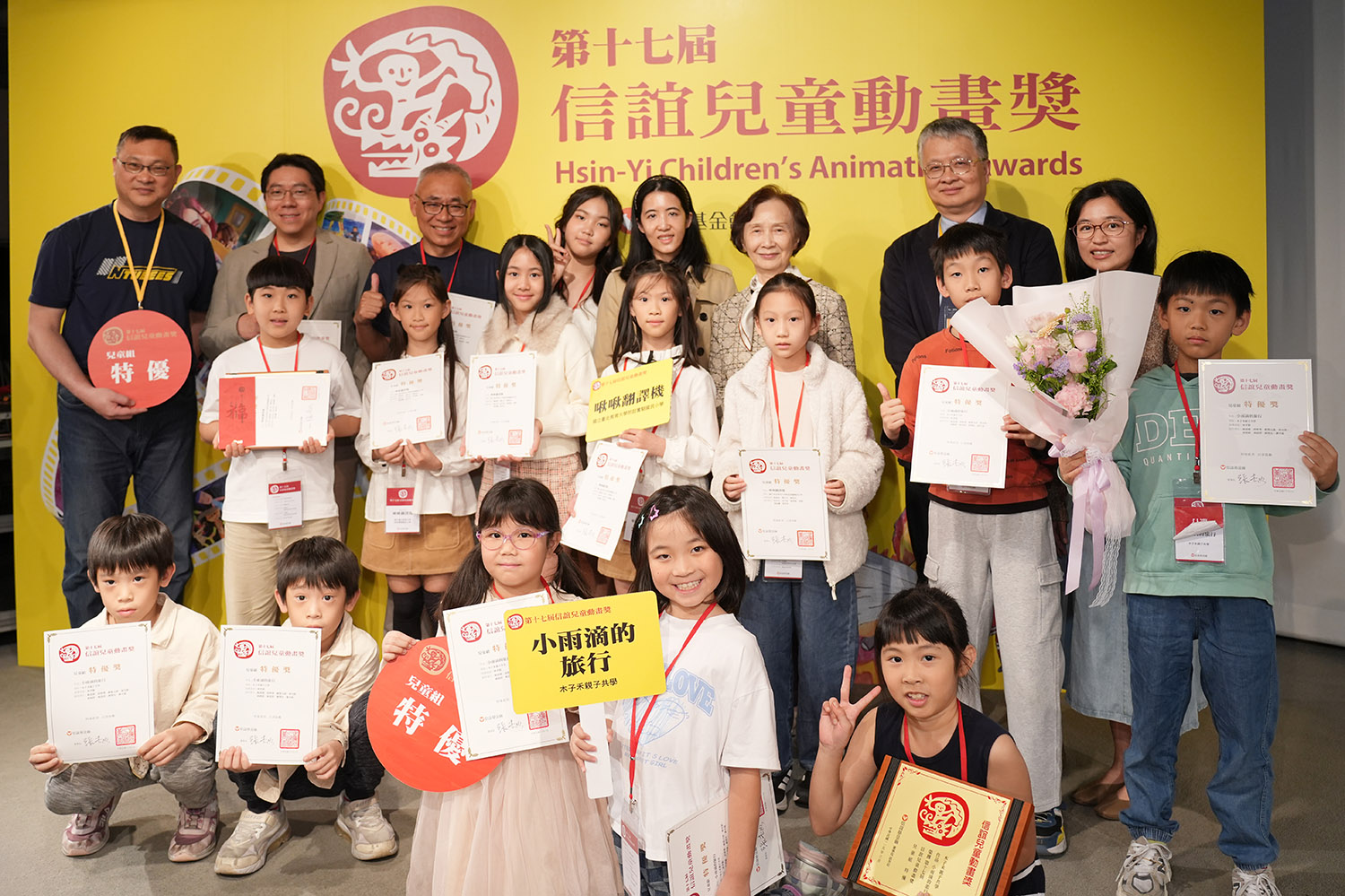 教育部次長劉國偉(後右1)、信誼基金會董事長張杏如(後右2)與兒童組特優作品《啾啾翻譯機》、《小雨滴的旅行》師生合影。(信誼基金會提供)