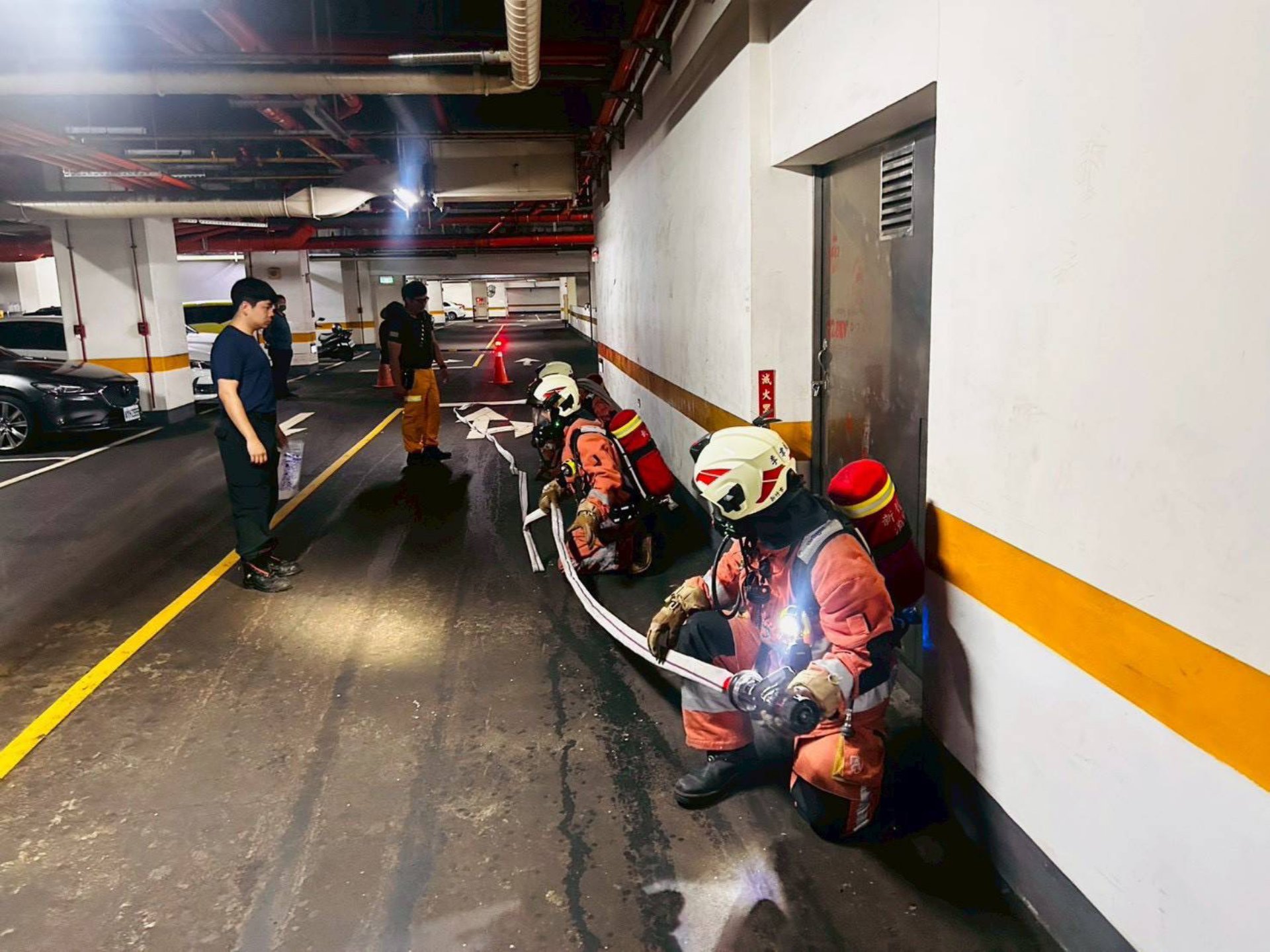 消防人員佈署水線進行火點搜索模擬。