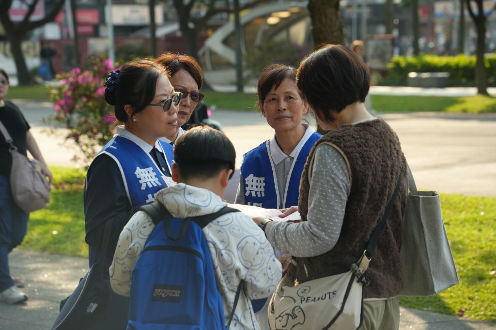 志工在臺大校門前發文宣,希望能邀請更多年輕人挽起袖子參加驗血建檔。