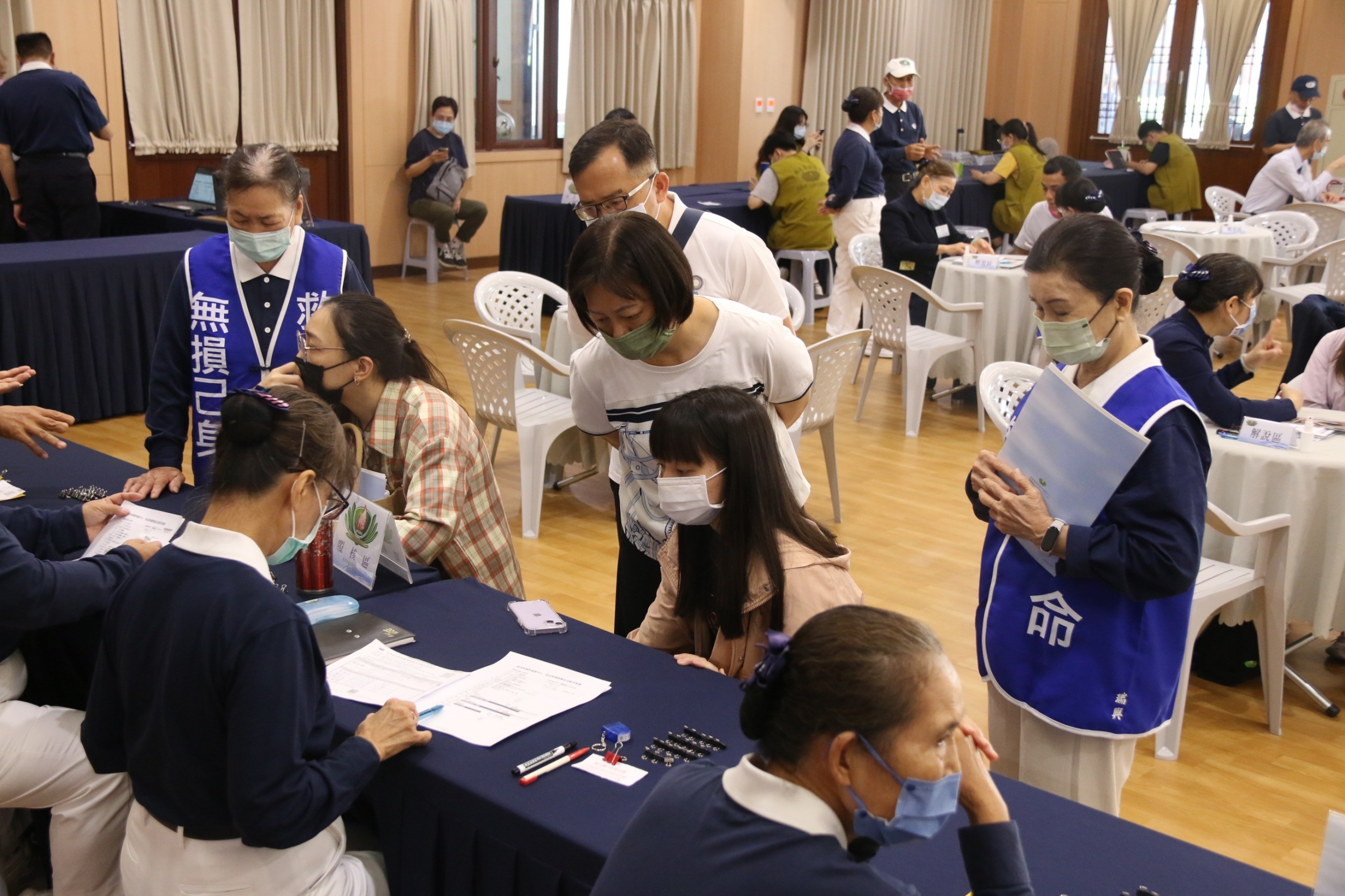 堂內，54位建檔者帶著期待與好奇踏入溫暖空間，250位志工各司其職，從資料填寫到抽血準備，用心守護每一個細節，現場洋溢著愛與關懷。