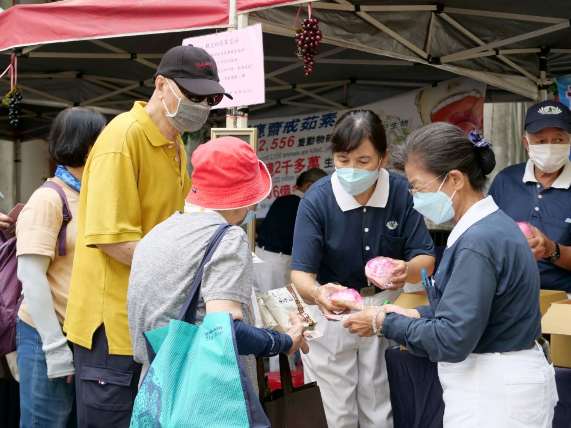 慈濟志工陳秉志（右一)、鄭秀美(右二)、趙金麥（右三）向民眾發送壽桃，每位領到結緣品的會眾，都非常開心且感謝志工的辛勞。
