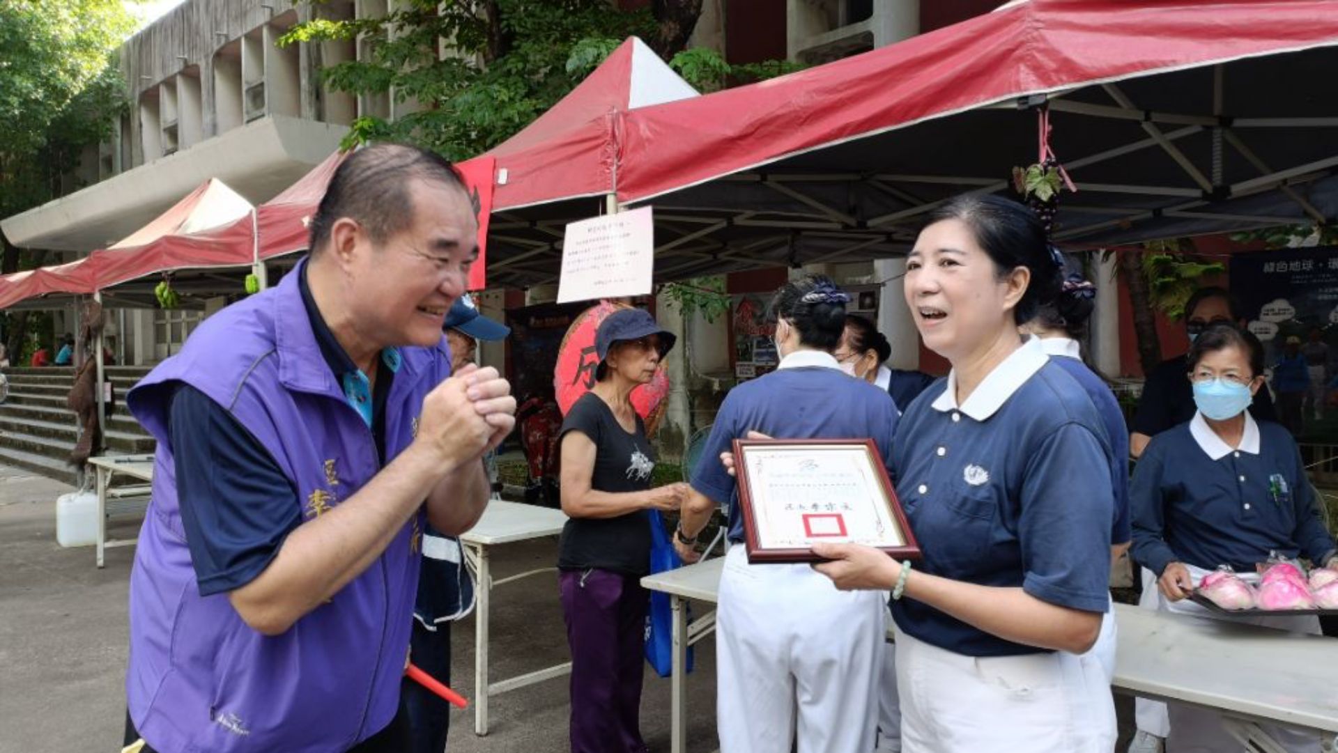 新興區區長李宗文(左)邀集多個協辦單位，讓現場不只義剪、肩頸推拿按摩、民俗療法等多元體驗，更有蔬食宣導，志工楊麗蘭表示，慈濟基金會新興共修處即扮演愛地球、多蔬食的重要推廣角色。