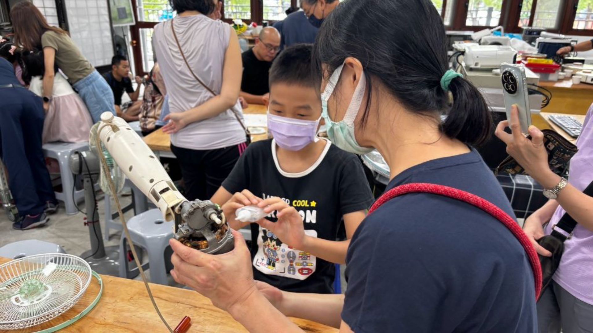 從認識電風扇構造、了解零件,到實際拆卸螺絲、清洗零件、替線圈上油,再重新組裝,孩子們在技師身旁專注觀察,輪流拿起工具嘗試。