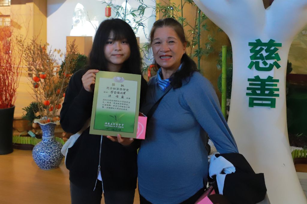 孫同學（左）參加2026年新芽獎學金頒獎典禮，於新店靜思堂與阿嬤李女士合影留念。
