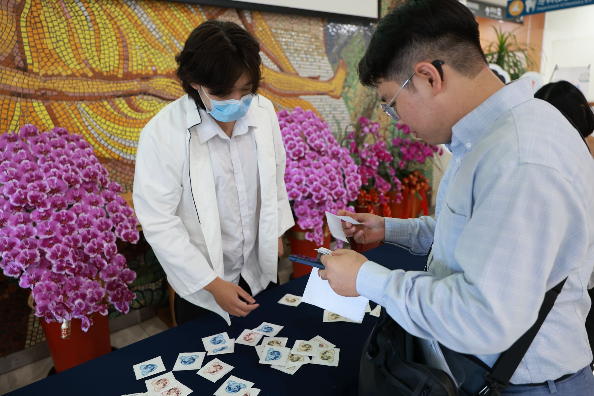 營養科謝淳雅營養師與門診大聽民眾，透過衛教有獎徵答，兌換毛豆豆漿卡士達蛋糕。